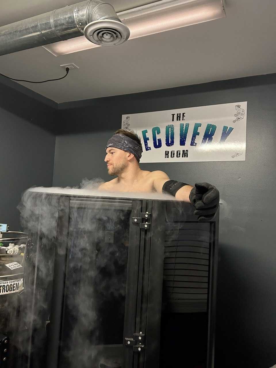 Thibault standing in a whole-body cryotherapy chamber with vapor rising, wearing a forehead sensor band. Whole-body cryotherapy, checking how tissue oxygenation signals behave at about -190 °F.