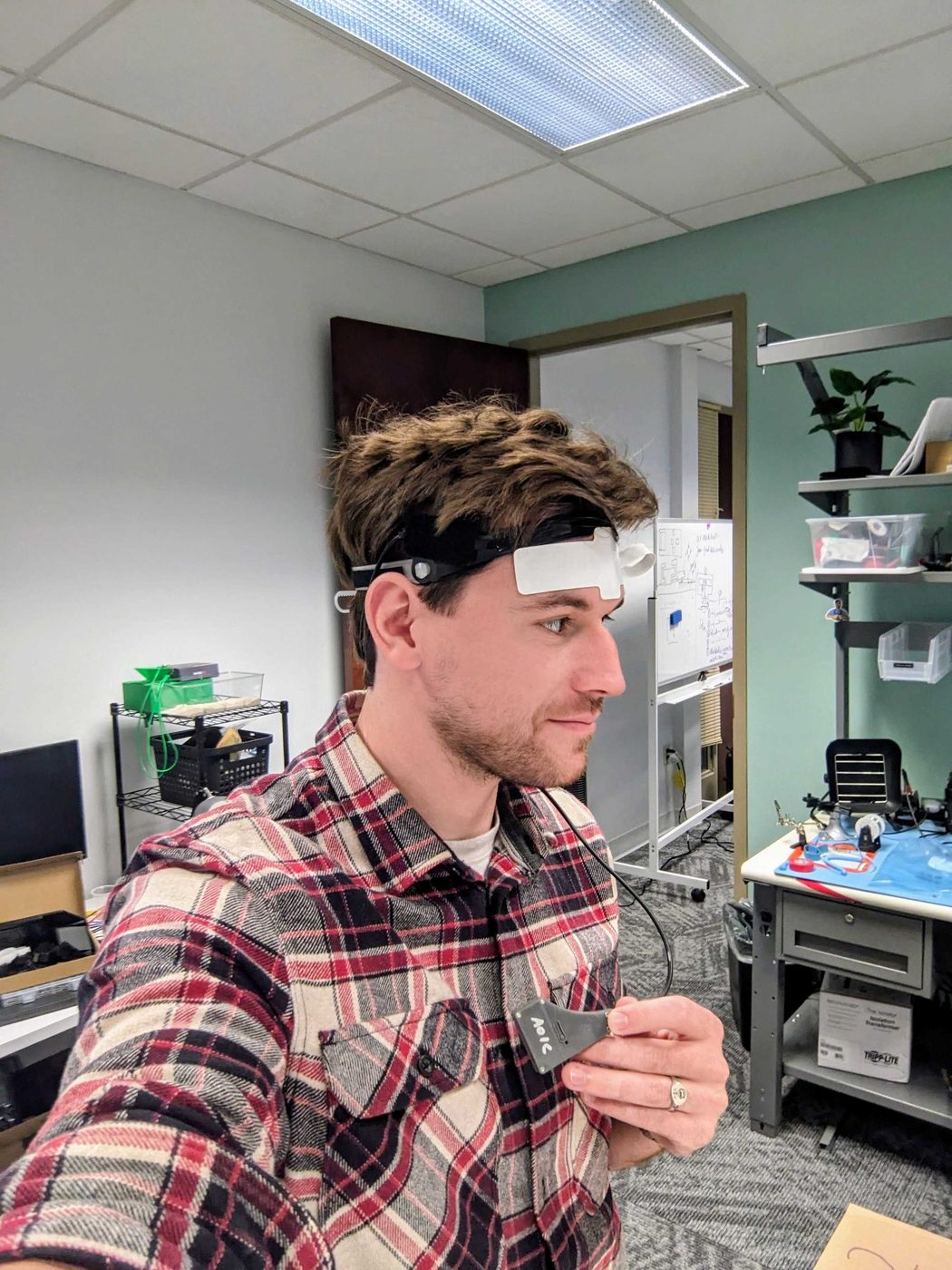 Thibault wearing a forehead sensor band, holding the cable module at his chest